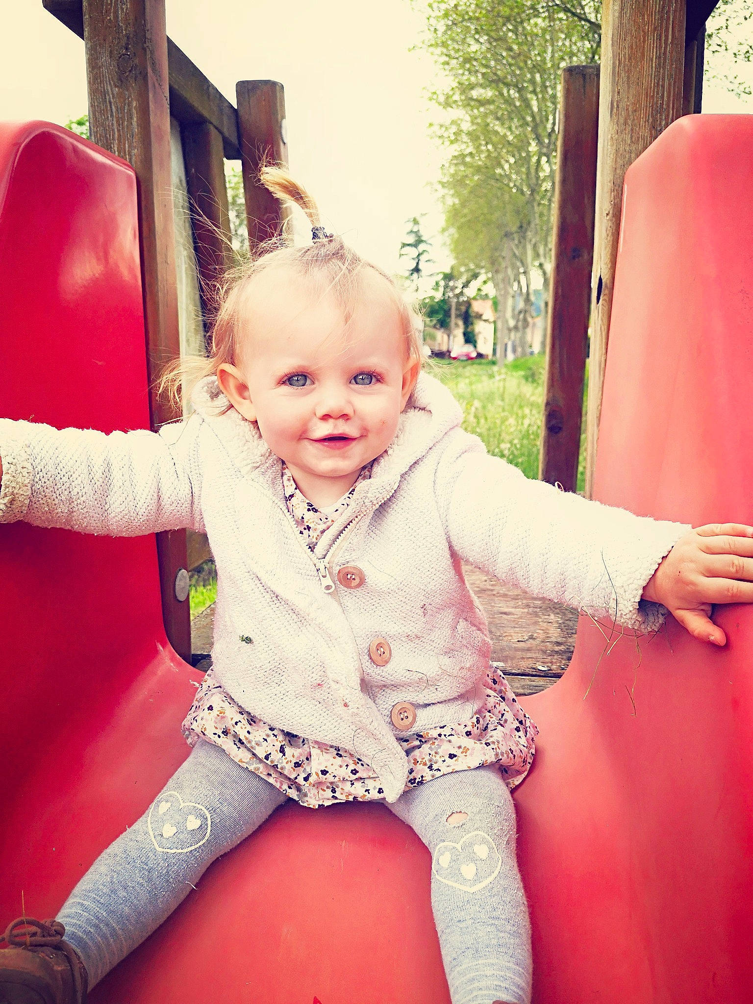 Fanny participe au concours pour gagner de l'argent avec cette photo : beauty, blond, child, child_model, eye, face, fun, head, leg, lip, outdoor_play_equipment, person, pink, playground, public_space, red, sitting, skin, smile, toddler