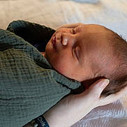 Christopher is registered to the contest to win money with this photo: newborn, baby, sleeping, blanket, hand, skin, face, infant, wrapped, peaceful, portrait, closeup, soft_light, resting, human, child, toddler, bed, comfort, care