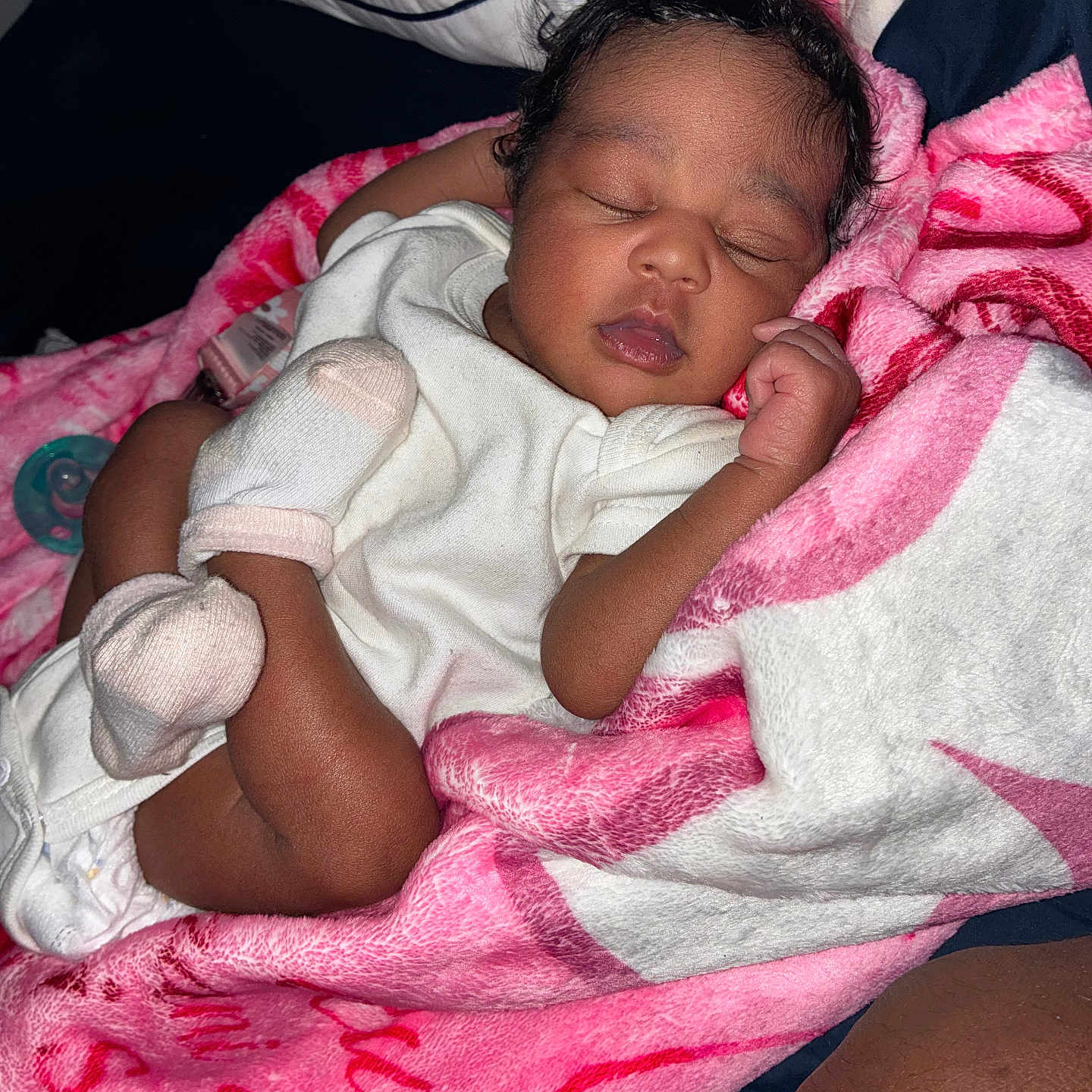 Rumani is registered to the contest to win money with this photo: newborn, baby, sleeping, infant, portrait, face, curled_up, blanket, pink_blanket, white_clothing, onesie, mittens, bed, bedding, pacifier, peaceful, indoors, close_up, resting, adorable
