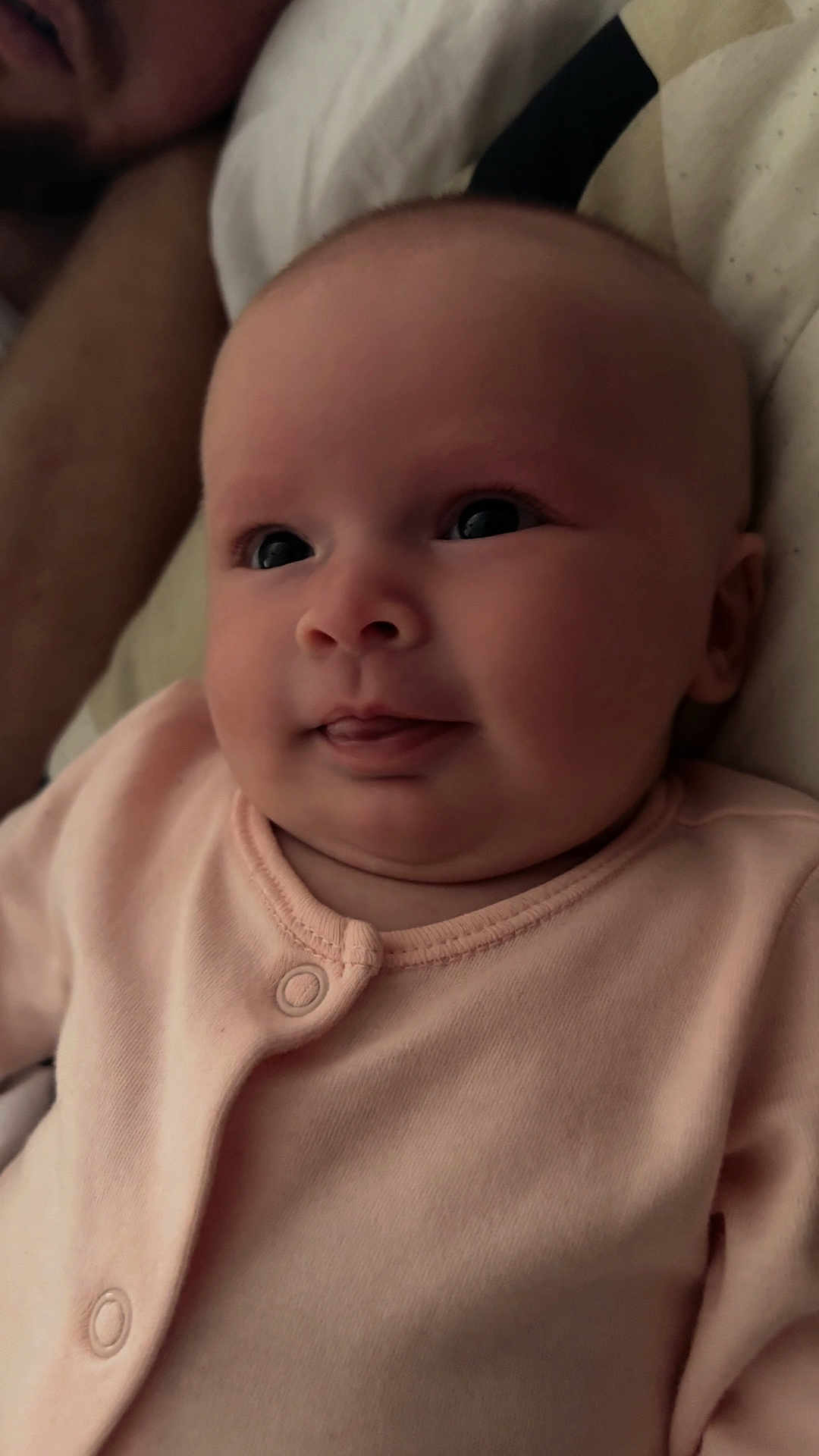 Gracie-Leigh is registered to the contest to win money with this photo: baby, infant, face, tongue, pink_clothing, onesie, closeup, expression, person, skin, cheeks, bed, bedding, adult, blurred_background, sleeping, resting, indoor, portrait, cute