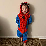Julian is registered to the contest to win money with this photo: child, smile, spiderman_costume, onesie, barefoot, carpet, indoor, happy, pose, wall, boy, costume, hood, standing, home, cute, playful, casual, portrait, fun