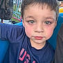 Julian is registered to the contest to win money with this photo: amusement_park, backpack, blue_shirt, boy, casual_clothing, child, closeup, daylight, expressionless, face, green_eyes, hair, outdoor, person, portrait, ride, rosy_cheeks, seat, usa, young_child