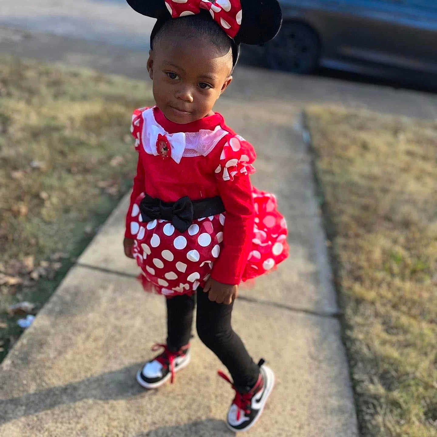 London is registered to the contest to win money with this photo: child, city, clothing, dress, face, female, footwear, girl, head, path, pedestrian, person, photography, portrait, road, shoe, sitting, sleeve, street, urban