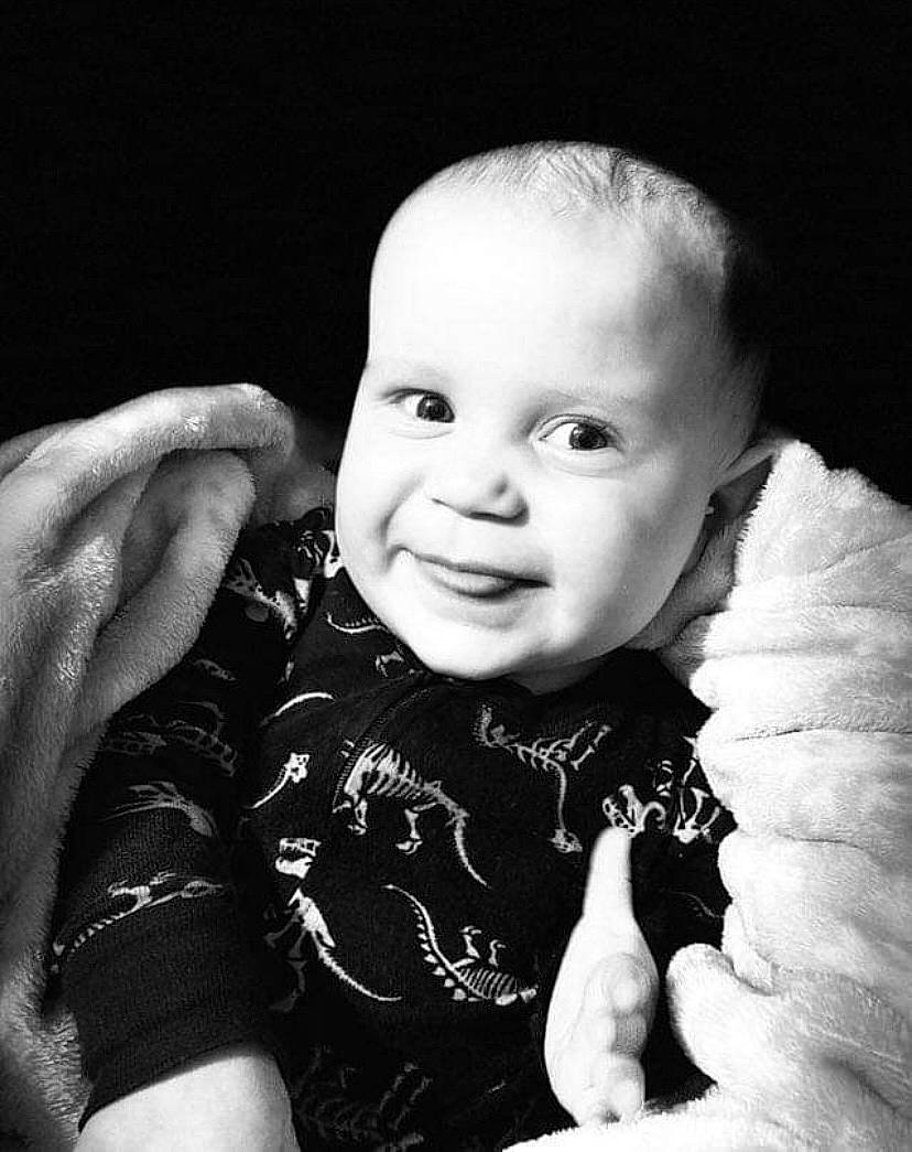 Greyson is registered to the contest to win money with this photo: arm, baby_toddler_clothing, black, black_and_white, cheek, eye, finger, flash_photography, gesture, hand, happy, human, iris, lip, organ, person, photograph, skin, sleeve, smile
