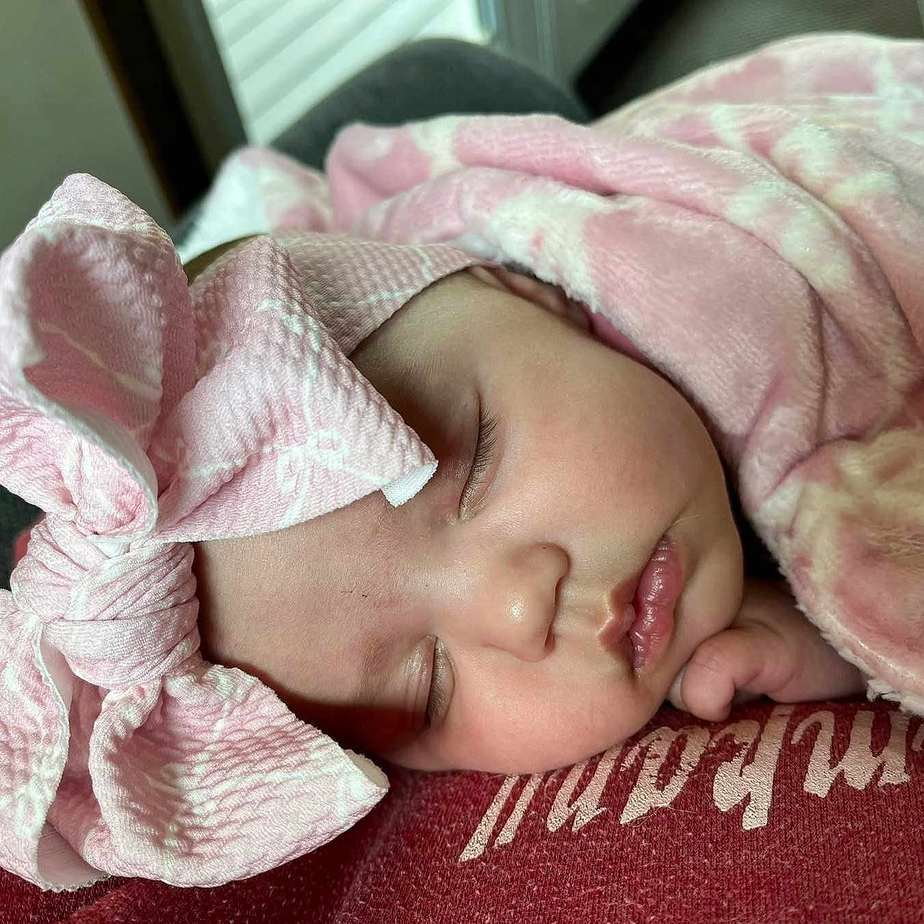 Iris is registered to the contest to win money with this photo: baby, blanket, bonnet, clothing, cushion, face, hat, head, homedecor, newborn, person, sleeping, towel