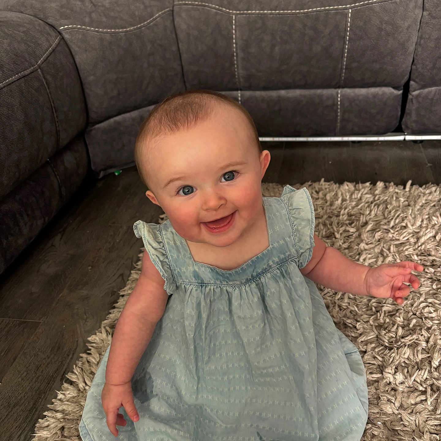 Enslee joined the competition — help win amazing prizes! baby, blue_dress, carpet, child, couch, cozy, cute, floor, furniture, happy, indoor, infant, living_room, person, pillow, portrait, rug, sitting, smiling, young_child