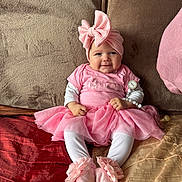 Paula participe au concours pour gagner de l'argent avec cette photo : baby, pink, tutu, headwrap, pacifier, couch, smile, sitting, cute, child, indoors, soft_toys, clothing, footwear, face, person, infant, fabric, home, accessory