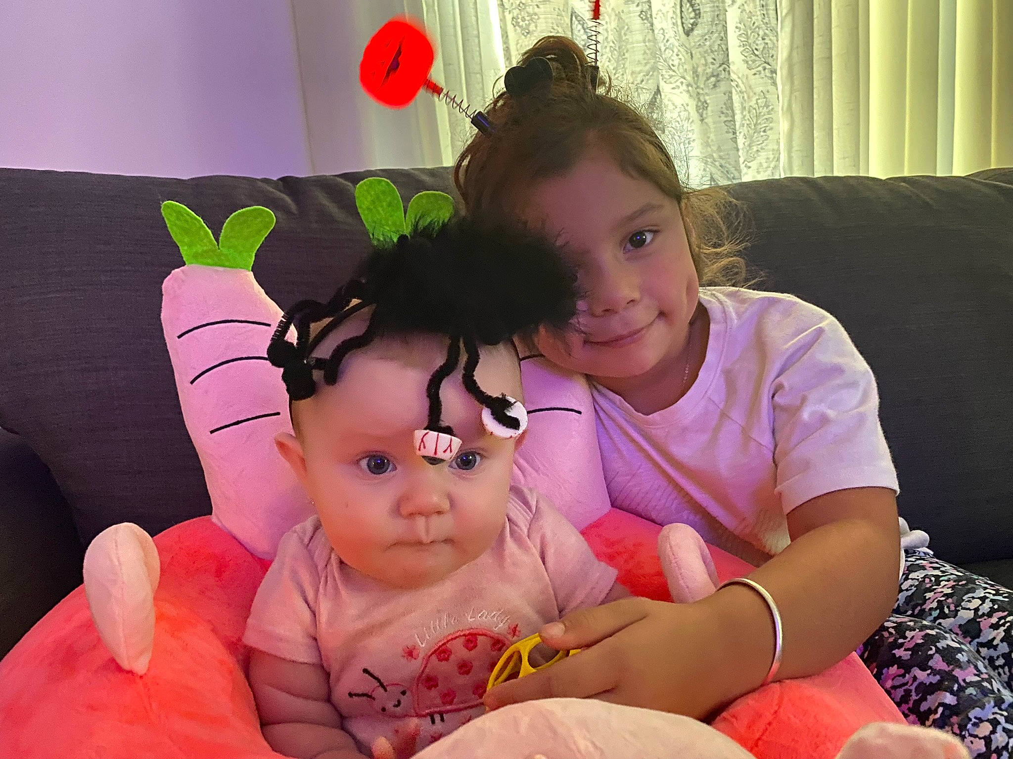 Felicity is registered to the contest to win money with this photo: arm, baby, baby_toddler_clothing, cheek, child, comfort, couch, curtain, eye, facial_expression, fun, gesture, happy, joy, lap, person, pink, playing_with_kids, sharing, skin