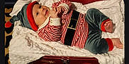 Charlie joined the competition — help win amazing prizes! baby, infant, child, holiday_costume, elf_hat, striped_shirt, velvet_pants, blanket, red_box, smile, cute, indoors, portrait, holiday_theme, festive, soft_texture, feet, hands, happy, lying_down