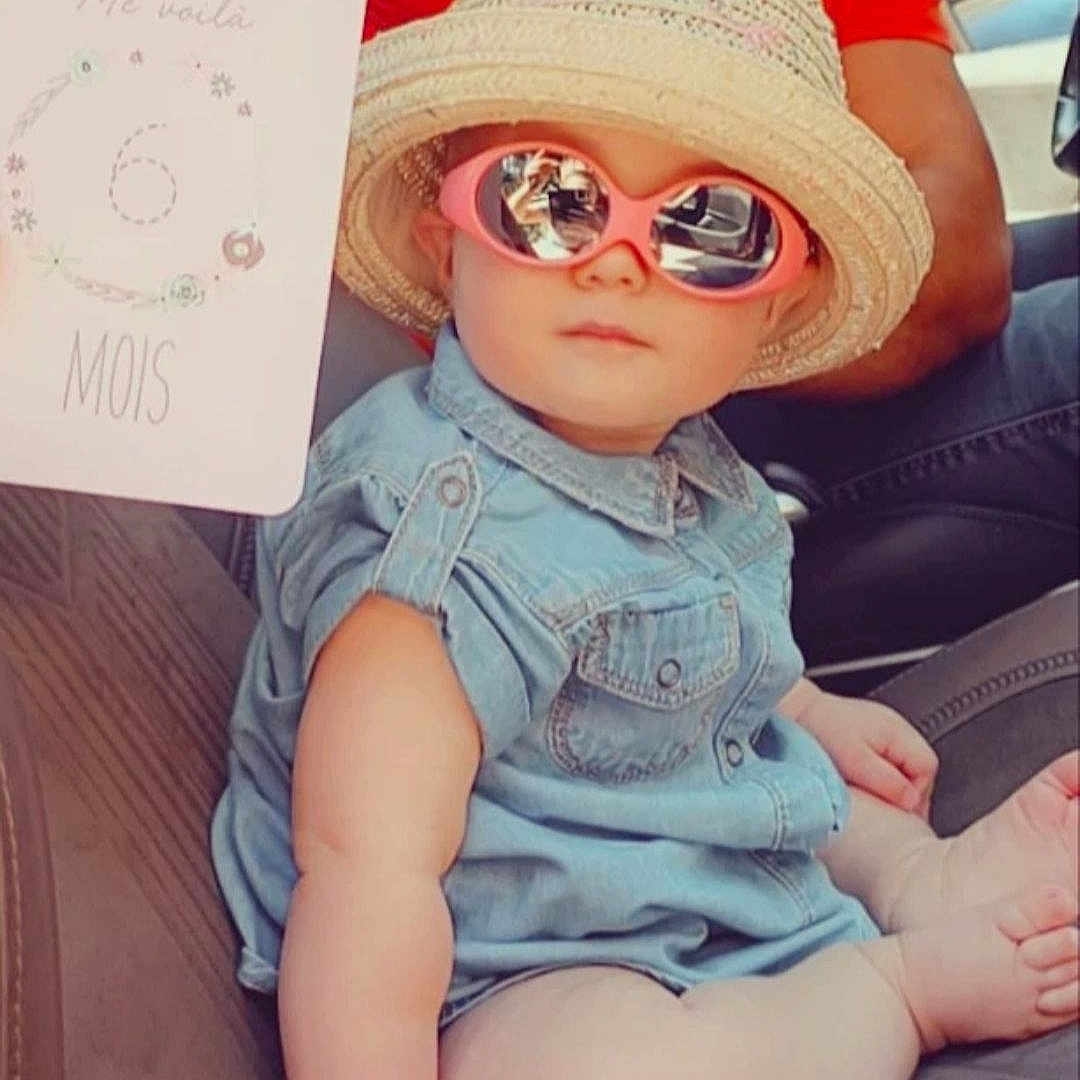 Thaïs participe au concours pour gagner de l'argent avec cette photo : baby_toddler_clothing, cap, cool, doll, dress, eyewear, glasses, goggles, hat, leg, lip, pink, skin, sleeve, sun_hat, sunglasses, textile, thigh, toy, vision_care