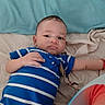 baby, infant, blue_onesie, striped_clothing, bed, sheet, blue_sheet, lying_down, curious_expression, child, person, indoor, cute, small_hand, puckered_lips, casual, relaxed, skin, head, face