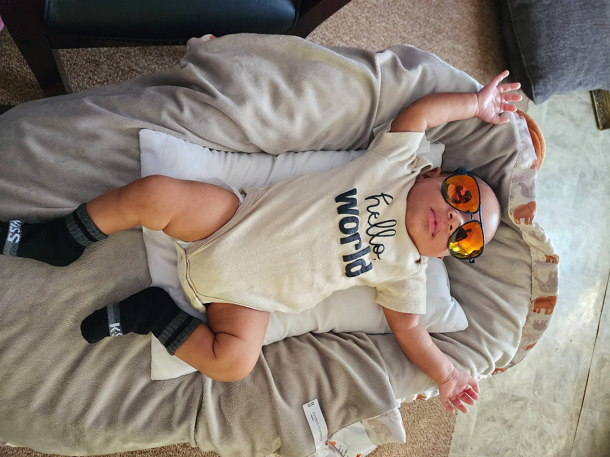 Angelo is registered to the contest to win money with this photo: baby, baby_toddler_clothing, comfort, elbow, finger, fun, hand, hat, human_body, human_leg, joint, knee, leg, linens, person, product, sitting, sleeve, t_shirt, thigh