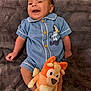 Jevonne is registered to the contest to win money with this photo: baby, infant, smiling, blue_clothing, romper, plush_toy, orange, blanket, soft_texture, lying_down, happy, cute, child, indoors, person, small_child, toy, comfort, cozy, portrait