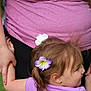 Deliah is registered to the contest to win money with this photo: child, adult, hand_holding, flower_hair_accessory, tattoo, purple_shirt, pink_shirt, outdoor, grass, person, portrait, cute, hair, skin, nature, casual_clothing, friendship, family, toddler, human