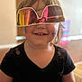 Deliah is registered to the contest to win money with this photo: child, smile, sunglasses, indoor, reflection, black_shirt, face_paint, happy, portrait, short_hair, young, playful, casual_clothing, closeup, person, light, room, blurred_background, fun, cute