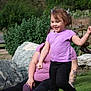 Deliah is registered to the contest to win money with this photo: child, adult, grass, rocks, outdoor, nature, tree, plant, purple_shirt, black_pants, tattoo, wheel, happy, running, smile, person, casual_clothing, daylight, fun, recreation