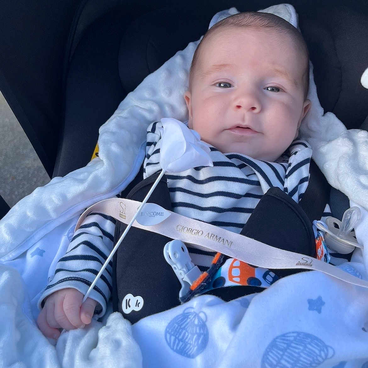 Elizio participe au concours pour gagner de l'argent avec cette photo : baby, blanket, blue, child, comfort, cozy, cute, face, hand, indoor, infant, pacifier, pattern, peaceful, resting, soft_texture, striped_clothing, stroller, white, young