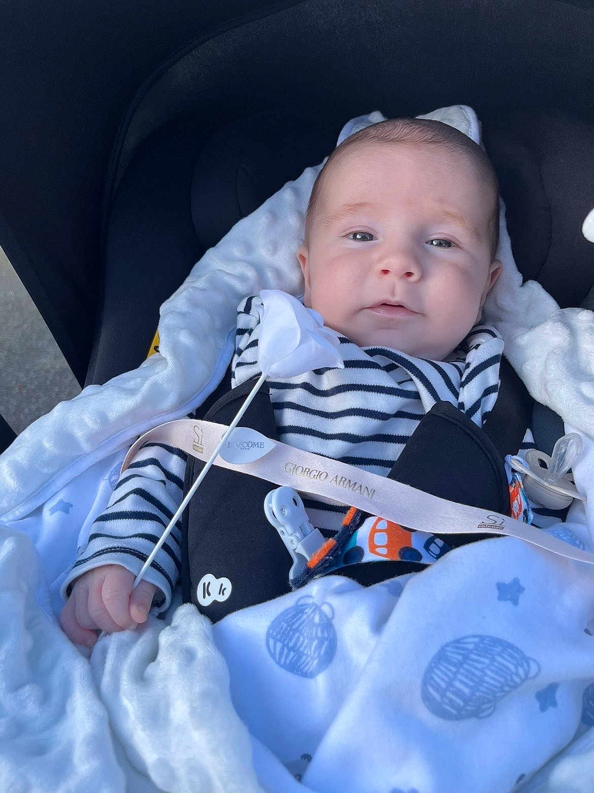 Elizio participe au concours pour gagner de l'argent avec cette photo : baby, infant, blanket, stroller, pacifier, striped_clothing, hand, face, comfort, cozy, child, young, cute, resting, soft_texture, white, blue, pattern, indoor, peaceful