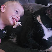 Colin joined the competition — help win amazing prizes! toddler, child, pacifier, cat, black_and_white_cat, couch, indoor, smile, happy, pet, animal, face, person, fur, relaxing, closeup, domestic, friendship, young_child, leisure
