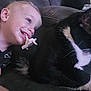 toddler, child, pacifier, cat, black_and_white_cat, couch, indoor, smile, happy, pet, animal, face, person, fur, relaxing, closeup, domestic, friendship, young_child, leisure