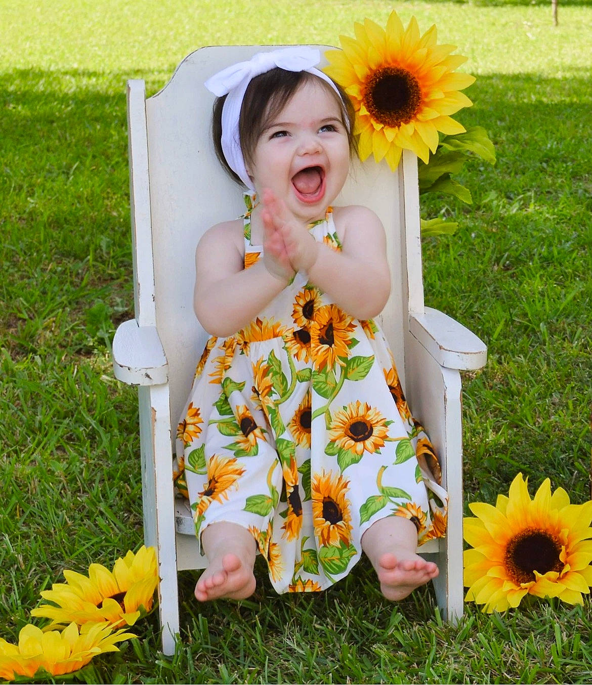 Madilynn is registered to the contest to win money with this photo: baby_toddler_clothing, chair, child, dress, flower, grass, happy, leaf, orange, pattern, people_in_nature, person, petal, photograph, plant, sitting, smile, spring, summer, toddler