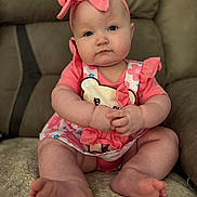 Raeli joined the competition — help win amazing prizes! baby, child, infant, pink_clothing, headband, bow, sitting, soft_surface, cute, portrait, indoor, plush, feet, hands, face, blue_eyes, furniture, couch, closeup, expression