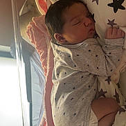 Ariana a rejoint le concours — aidez-le/la à gagner de superbes lots ! newborn, baby, sleeping, infant, onesie, star_pattern, pillow, blanket, plush_toy, bunny, hospital_bassinet, foot, hand, face, cute, cozy, indoor, soft_lighting, peaceful, resting