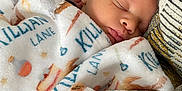 Killian is registered to the contest to win money with this photo: baby, sleeping, blanket, cozy, infant, face, peaceful, cushion, soft, resting, child, portrait, closeup, indoor, cute, newborn, comfort, warm, relaxation, person