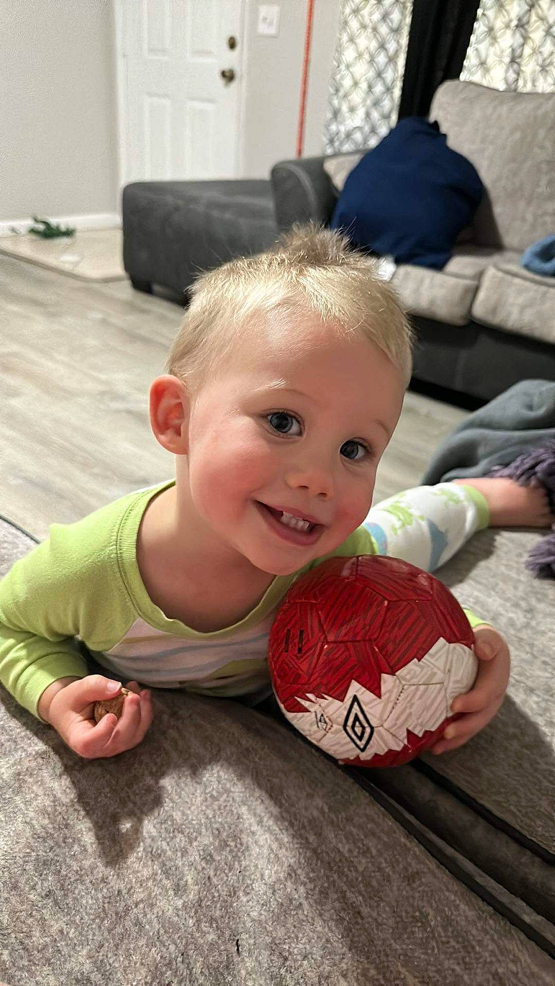 Landon joined the competition — help win amazing prizes! baby, baby_toddler_clothing, ball, child, couch, flooring, foot, football, fun, happy, hardwood, joy, leisure, person, play, sitting, smile, soccer_ball, sports_equipment, toddler