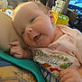 Brooklynn is registered to the contest to win money with this photo: arm, baby, cartoon_characters, close_up, colorful, face, furniture, hand, happy, indoor, infant, onesie, person, resting, skin, smiling, tattoo, television, text_on_clothing, toy