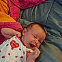 baby, bed, blanket, blue, clothing, cozy, cute, face, hand, happy, infant, ladybug, newborn, pattern, pink, portrait, red, sleepwear, smile, white
