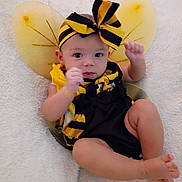 Aaliyah joined the competition — help win amazing prizes! baby, infant, costume, bee, wings, headband, bow, black_and_yellow, legs, arms, blanket, soft, cute, child, portrait, indoors, clothing, person, lying_down, skin