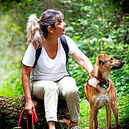 Angy a rejoint le concours — aidez-le/la à gagner de superbes lots ! woman, dog, forest, log, leash, nature, greenery, outdoor, pet, animal, casual_clothing, short_sleeves, sitting, standing, collar, daylight, adventure, exploration, companionship, walking