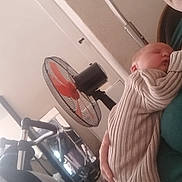 Harry joined the competition — help win amazing prizes! baby, person, sleeping, striped_clothing, fan, orange_blades, indoor, holding, seated, home, relaxed, comfort, furniture, mirror, exercise_equipment, skin, face, hand, casual, quiet