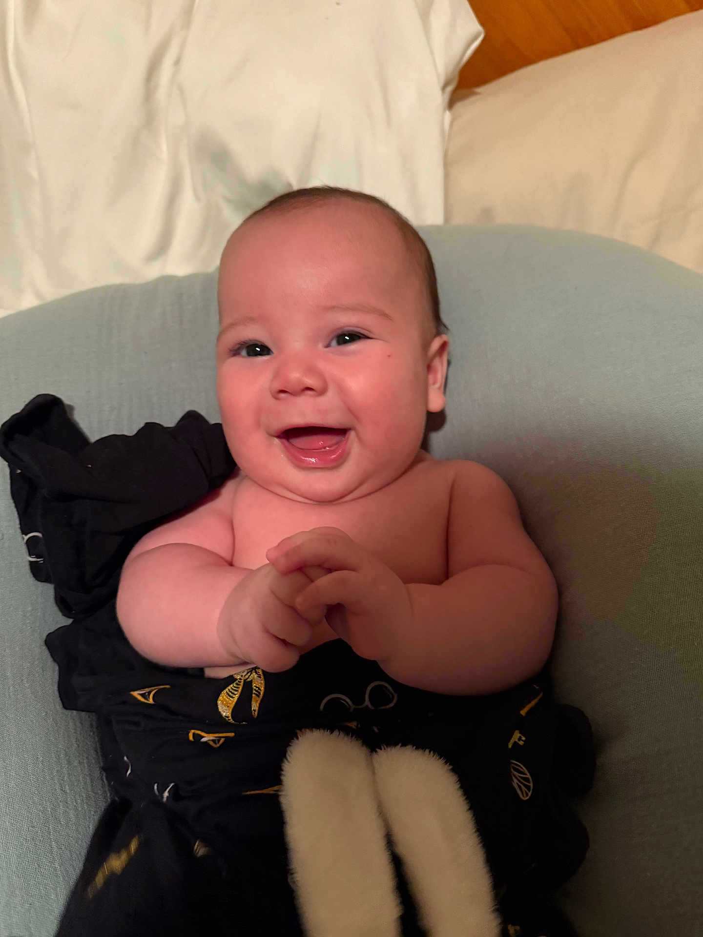 Weston is registered to the contest to win money with this photo: baby, smiling, infant, happy, hands, cushion, blanket, skin, face, chubby_cheeks, sitting, indoors, clothing, comfort, cute, portrait, warm_lighting, young_child, baby_boy, expression