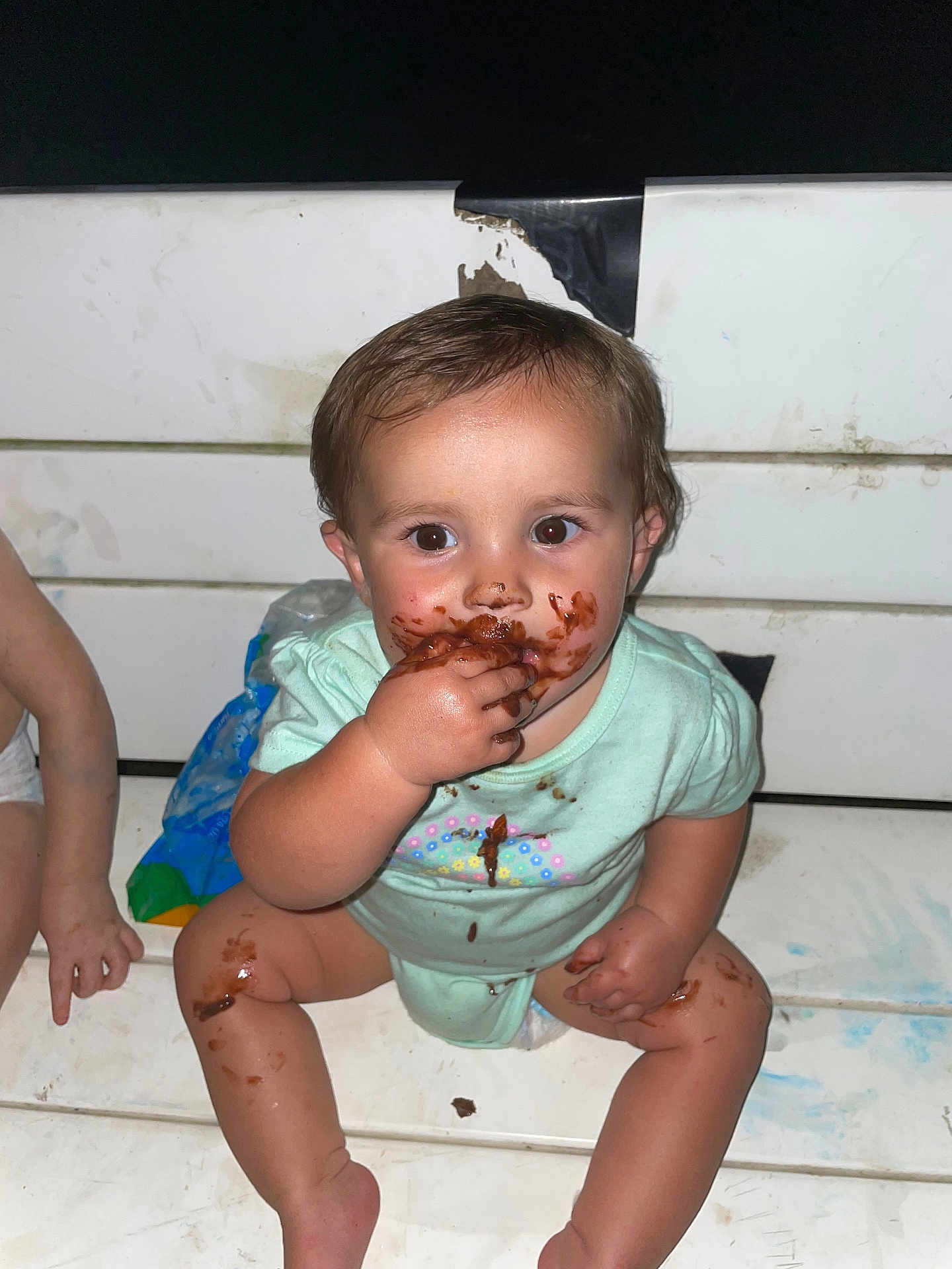 Jazmine is registered to the contest to win money with this photo: toddler, child, messy, chocolate, face, hands, sitting, bench, clothing, diaper, food, happy, indoor, cute, person, brown_hair, skin, smiling, playful, dirty