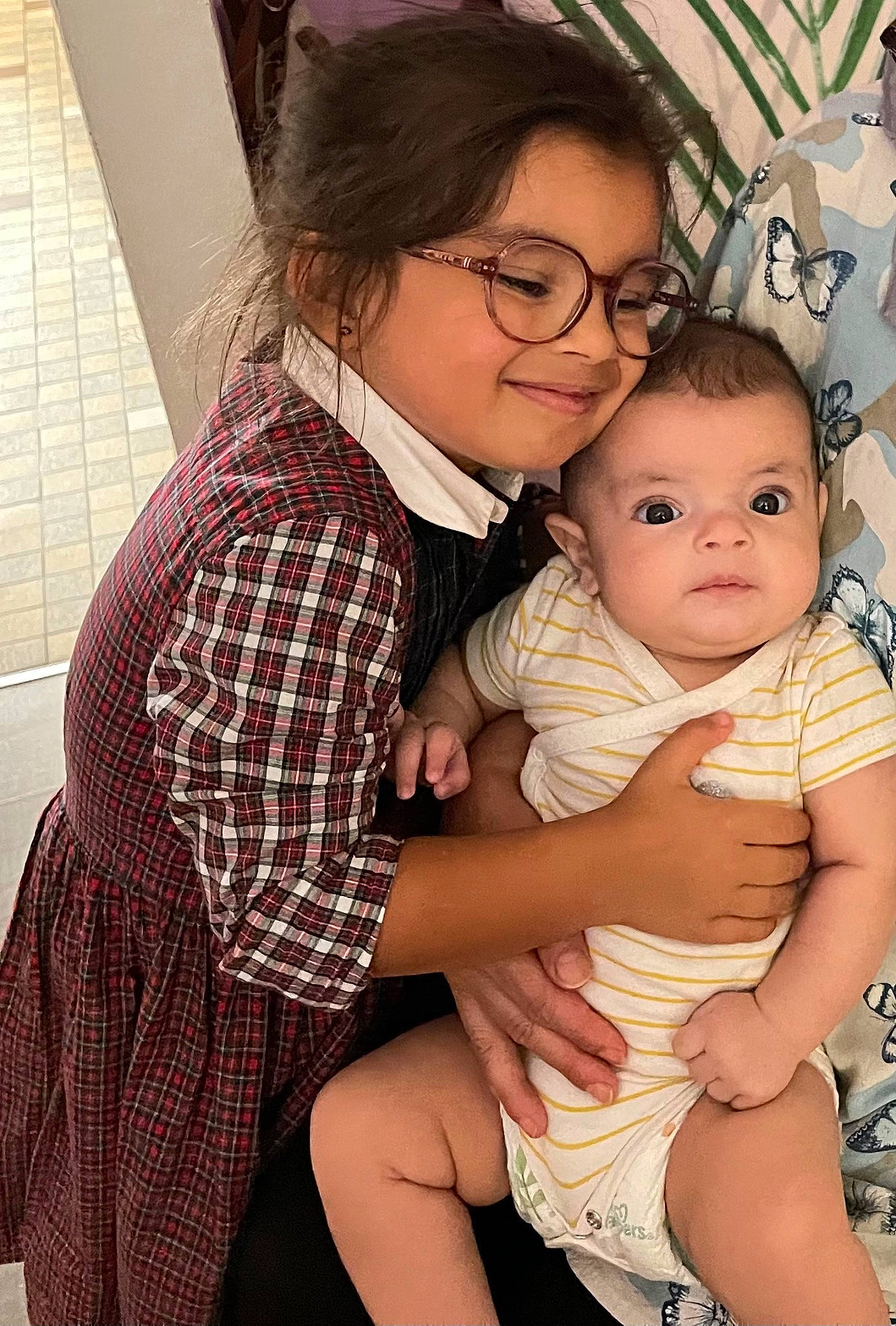 Jennah a rejoint le concours — aidez-le/la à gagner de superbes lots ! baby, baby_toddler_clothing, black_hair, cheek, child, event, eyewear, flash_photography, fun, gesture, glasses, happy, joy, person, plaid, sitting, skin, smile, tartan, thigh