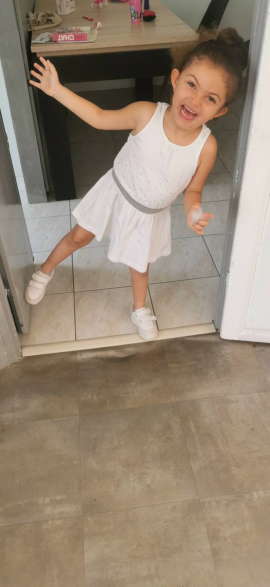 Kaïna participe au concours pour gagner de l'argent avec cette photo : baby_toddler_clothing, barefoot, calf, door, elbow, floor, flooring, foot, gesture, happy, hardwood, human_leg, joy, knee, leg, person, smile, stairs, thigh, toddler