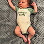 baby, infant, onesie, clothing, text, blanket, gray, lying_down, arms_up, legs, feet, cute, face, skin, newborn, person, indoors, sleepwear, soft, comfortable