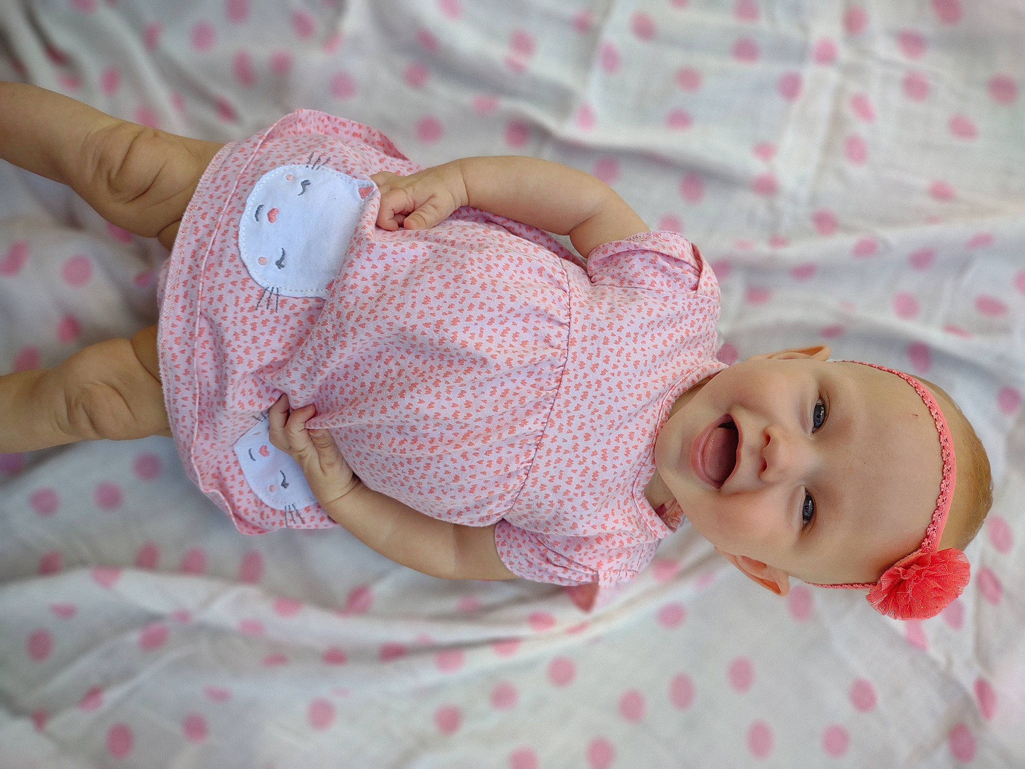 Amelia Christine Collins is registered to the contest to win money with this photo: arm, baby, baby_toddler_clothing, cheek, dress, eye, finger, hand, head, headgear, headwear, human_body, lip, pattern, person, pink, product, skin, sleeve, smile