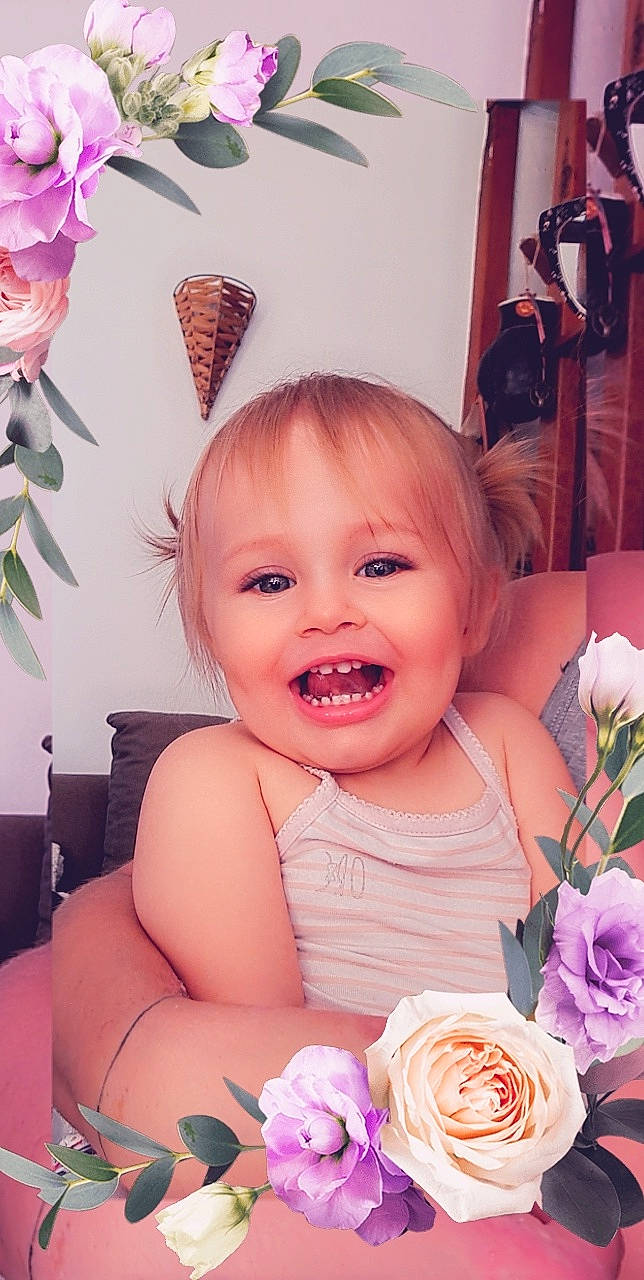 Maïwenn participe au concours pour gagner de l'argent avec cette photo : baby, baby_toddler_clothing, cheek, child, flower, hair_accessory, happy, hybrid_tea_rose, iris, joy, magenta, person, petal, pink, plant, product, rose, skin, smile, textile