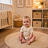 Aaron is registered to the contest to win money with this photo: baby, child, nursery, rug, floor, toy, teddy_bear, lamp, shelf, basket, wooden_floor, plush_toy, window, light, cute, indoor, smiling, sitting, onesie, decor