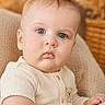 baby, blue_eyes, knit_clothing, teddy_bear, portrait, child, infant, close_up, seated, beige, chair, soft_lighting, warm_tones, indoor, cute, texture, face, expression, person, young_child