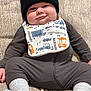 baby, infant, beanie, carhartt, bib, couch, cozy, cute, face, footwear, gray_socks, infant_clothing, indoors, person, ribbed_fabric, smile, texture, young_child, zipped_onesie, lying_down