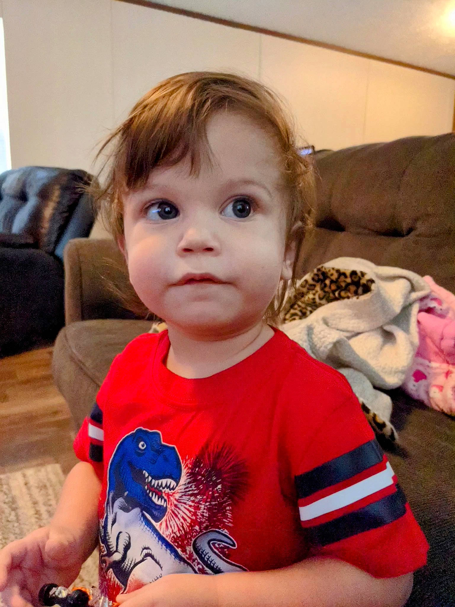 Axton is registered to the contest to win money with this photo: baby, baby_toddler_clothing, blond, cheek, child, christmas, comfort, couch, eyelash, fun, happy, head, holiday, living_room, nose, person, sitting, skin, sleeve, t_shirt