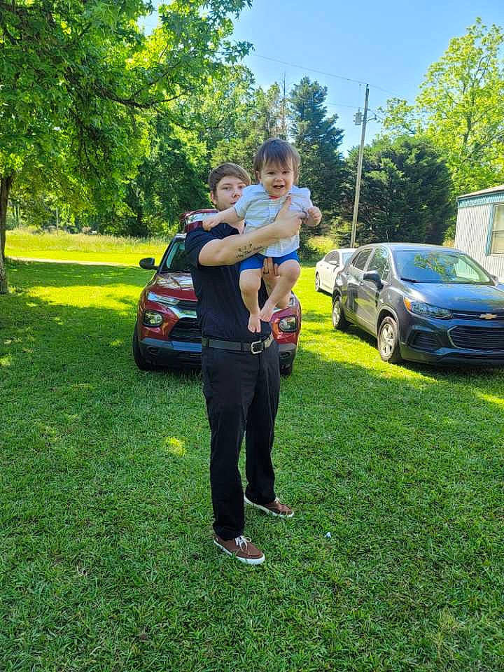 Axton is registered to the contest to win money with this photo: automotive_design, automotive_exterior, automotive_lighting, car, grass, joy, land_vehicle, landscape, lawn, leisure, motor_vehicle, person, plant, recreation, shorts, sky, tire, tree, vehicle, vehicle_door