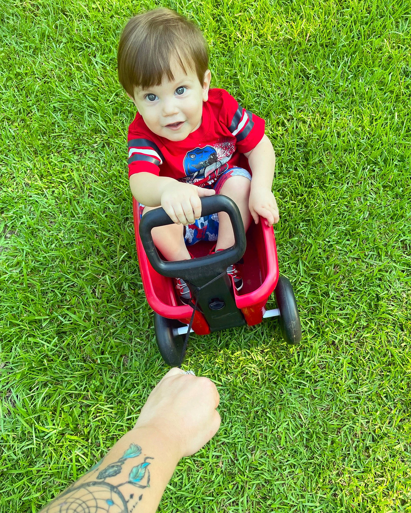 Axton joined the competition — help win amazing prizes! baby, baby_toddler_clothing, child, fun, grass, grassland, green, groundcover, happy, human_leg, lawn, leisure, meadow, people_in_nature, person, plant, recreation, riding_toy, sitting, toddler