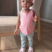 Saniyah Heaven joined the competition — help win amazing prizes! child, toddler, headband, bow, pink_shirt, jeans, slippers, indoor, chair, hardwood_floor, standing, portrait, furniture, home_interior, cute, hair, socks, hands, expression_neutral, footwear
