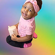 Saniyah Heaven joined the competition — help win amazing prizes! toddler, child, pink_headband, pink_shirt, black_pants, pink_socks, sippy_cup, smiling, sitting, cross_legged, happy, cute, portrait, indoor, colorful_background, headwear, young_child, person, baby, cheerful