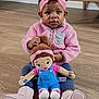 child, toddler, doll, pink_jacket, headband, indoor, wooden_floor, toy, blue_overalls, pink_boots, sitting, cute, person, portrait, young_child, floor, plush_toy, clothing, hair, serious_expression